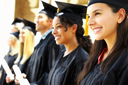 graduates smiling holding diplomas