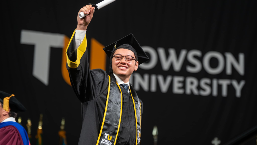 Towson graduate celebrating with diploma